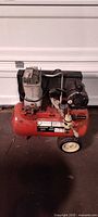 Full view of red Craftsman air compressor showing tank, motor, wheels