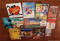 Group shot of 13 assorted children’s books laid on hardwood floor