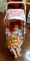 Front view of stroller with Ariel and Elsa dolls seated