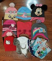 Group shot of all eight hats and two neck warmers on floor