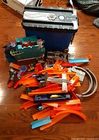 Overview showing blue storage bin, Shark Bite Bay parts, pile of orange track pieces