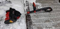 Side view of Jobmate handheld snow thrower on snowy walkway