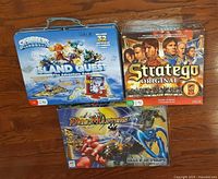 All three game boxes/tin displayed