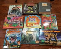 Group shot of nine dinosaur books laid out on floor