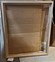 Natural MDF float frame with cardboard insert, open box condition visible