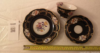 Full view of plate, saucer, cup with measuring tape showing sizes