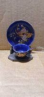 front view of miniature cobalt blue cup and saucer with stand
