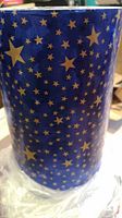 Close view of blue holographic wrapping paper roll showing gold star pattern