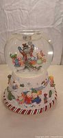 Front view of Partylite Peppermint Slide snow globe showing characters and base detail