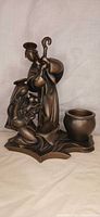Front view of bronze-finish nativity tealight holder showing figures and candle cup