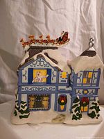 Front view of snow-covered house with Santa sleigh