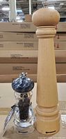 Tall natural wood pepper mill and small clear acrylic pepper mill with tag