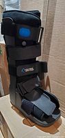 Side view of United Ortho Air Cam Walker fracture boot showing straps, shell, blue accent