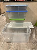 Stack of three medium totes with coloured lids atop under-bed tote