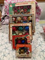 Front view of four boxed ornament sets showing box graphics and ornament colors
