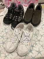 Overview showing all three pairs: Skechers, Clarks, white floral sneakers