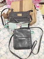 All four bags laid out: Tilley canvas, Tommy Hilfiger monogram, Studio Ghibli blue, black leather