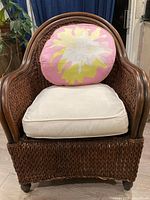 Front view of wicker armchair with cushion and pillow
