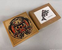 Both cedar boxes closed, showing artwork lids