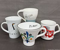 Front view of all four mugs showing artwork and shapes
