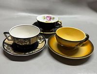 Three teacup and saucer sets arranged side by side