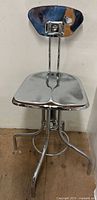 Full view of chrome stool showing backrest and seat