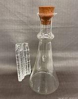 Full view of Dansk glass carafe with teak stopper alongside Rosenthal textured candleholder