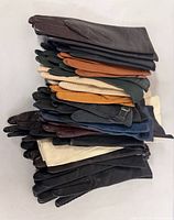 Stack of assorted glove pairs showing range of colours and materials