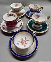 Five teacup and saucer sets displayed