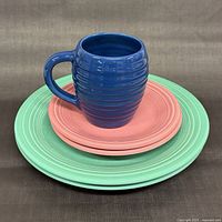 Blue Bauer mug on pink Fiesta plate on green Fiesta plate