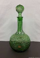 Full view of green glass decanter with stopper in place