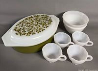 Casserole with lid, four cups, two bowls displayed