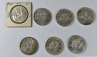 Seven Canadian Voyageur silver dollars, top-left in cardboard flip