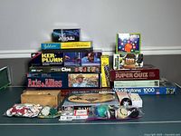 Overall lot showing stacked boxed games, puzzle, domino set, Chinese Checkers board, poker chips and marbles