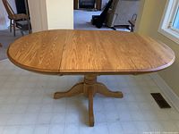 Full view of oak pedestal dining table with leaves inserted