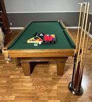 Pool table with accessories and cue stand visible