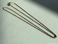 Full view of entire gold box chain necklace laid flat