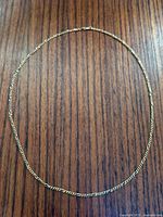 Full view of 10K gold chain laid flat on wooden surface