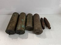 Front view of six clock weights showing forms and sizes