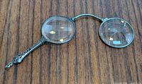 Overall view of unfolded sterling silver folding lorgnette showing cracked right lens
