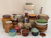 Group shot of entire pottery lot showing variety of crocks, bowls, vases, plates and cocottes