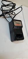 Front view of black 12V Pro-Series charger with battery slot and label