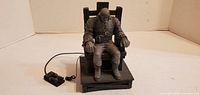 Front view of Marv figure strapped to electric chair with wired control