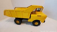Left side view of yellow Nylint dump truck