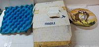 Foam insert, original shipping box marked Fragile, plate partly visible