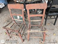 Front view of the two red primitive chairs without seats