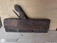 Left side view showing full wooden plane body, wedge and blade