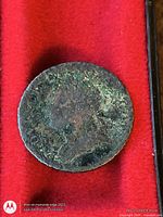 Obverse of dark toned copper coin in display case