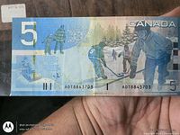 Reverse side showing hockey scene, denomination 5, serial AOT8843703