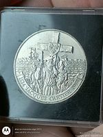 Reverse of coin showing Jacques Cartier scene in capsule